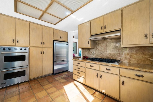 kitchen featuring backsplash, light brown cabinets, and stainless steel appliances