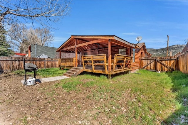 rear view of house featuring a yard and a deck