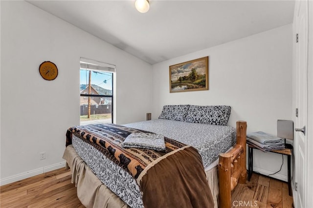 bedroom with lofted ceiling and light wood-type flooring