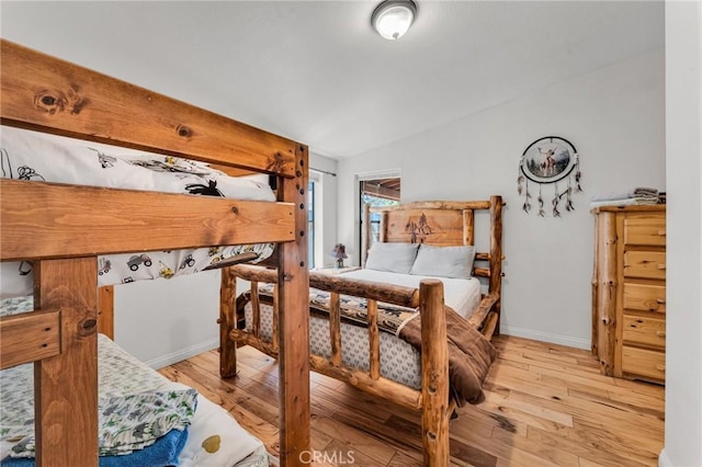 bedroom with light wood-type flooring and vaulted ceiling