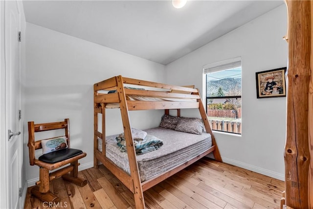 bedroom with light wood-type flooring and lofted ceiling