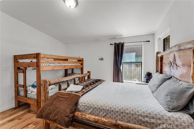 bedroom with light hardwood / wood-style floors and vaulted ceiling