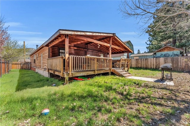 back of house with a wooden deck and a yard