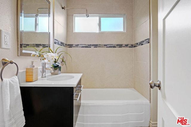 bathroom with plenty of natural light, vanity, and tiled shower / bath combo