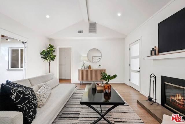 living room with vaulted ceiling with beams and light hardwood / wood-style flooring