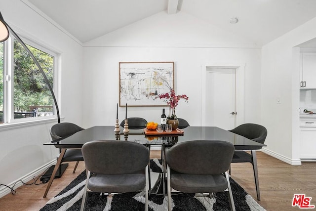 dining area featuring lofted ceiling with beams and light wood-type flooring