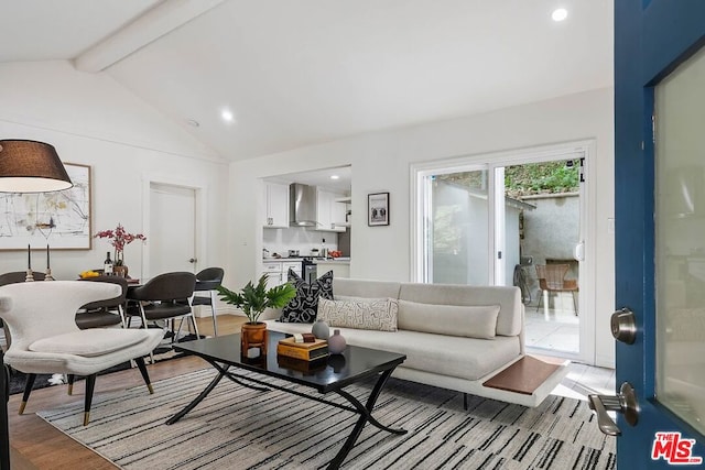 living room with vaulted ceiling with beams and light wood-type flooring