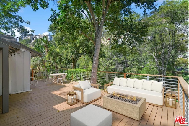 wooden terrace featuring an outdoor living space with a fire pit