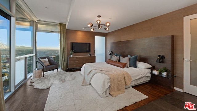 bedroom featuring a chandelier, floor to ceiling windows, and dark wood-type flooring