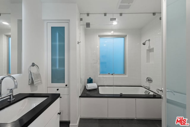 bathroom with tile patterned flooring, vanity, and combined bath / shower with glass door