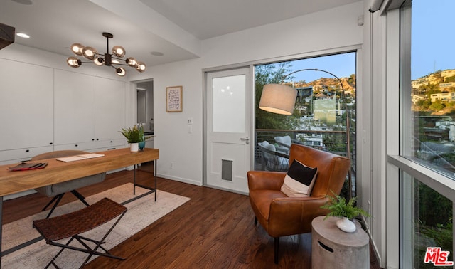 home office featuring dark wood-type flooring and a notable chandelier