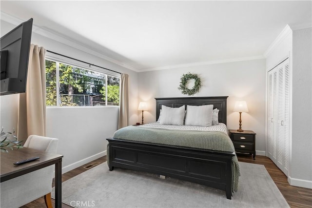 bedroom with dark hardwood / wood-style floors, a closet, and crown molding