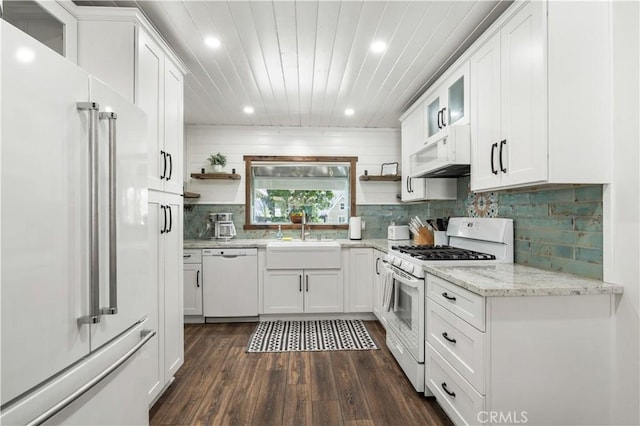 kitchen featuring white cabinetry, sink, light stone counters, dark hardwood / wood-style flooring, and white appliances