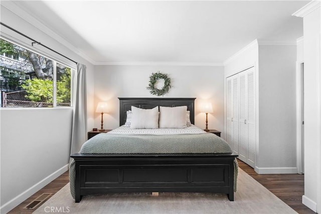 bedroom with ornamental molding, dark wood-type flooring, and a closet