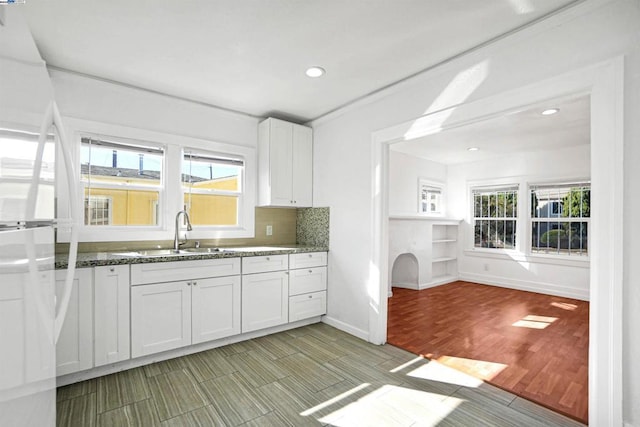 kitchen featuring white fridge, dark stone countertops, decorative backsplash, white cabinets, and sink