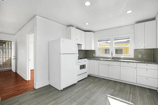 kitchen with white appliances, white cabinets, backsplash, and sink