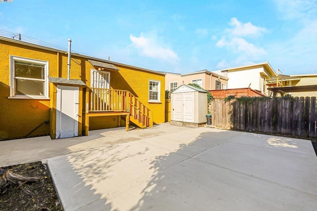 back of property with a patio area and a shed