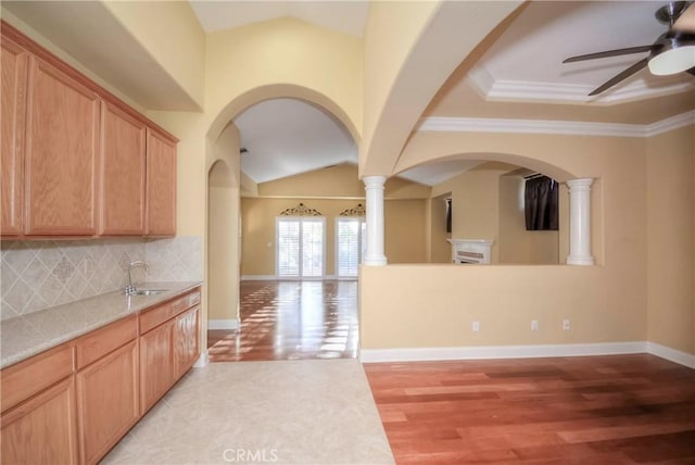 kitchen with backsplash, crown molding, sink, and light hardwood / wood-style floors