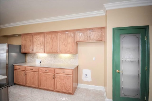 kitchen featuring decorative backsplash, ornamental molding, light tile patterned floors, light brown cabinets, and stainless steel refrigerator