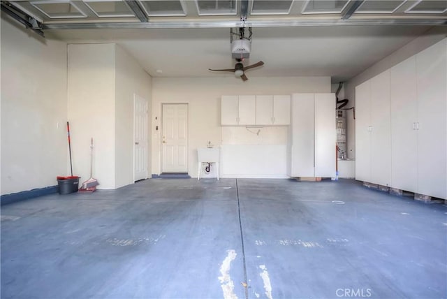 garage featuring ceiling fan, strapped water heater, and a garage door opener