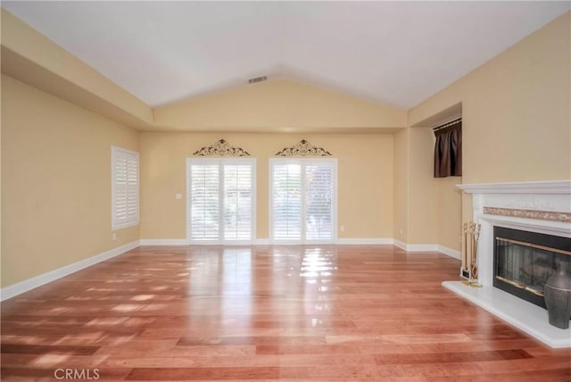 unfurnished living room with wood-type flooring and lofted ceiling