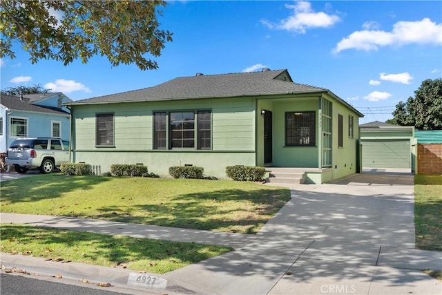 view of front of property featuring a garage, a front lawn, and an outdoor structure