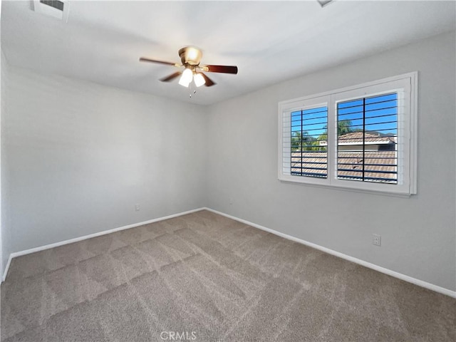 carpeted spare room featuring ceiling fan