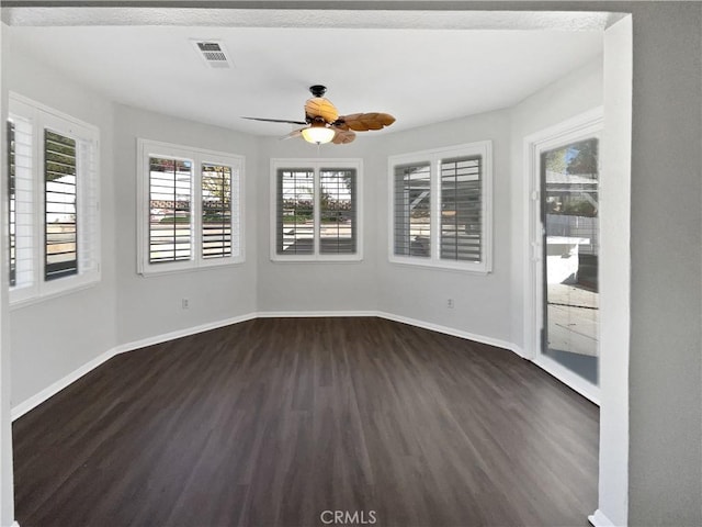 empty room with dark hardwood / wood-style floors and ceiling fan