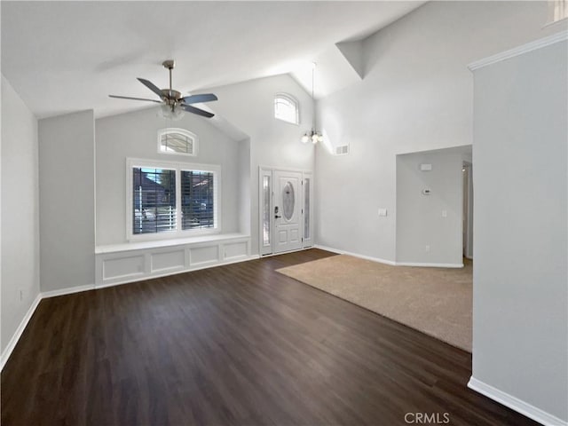 interior space featuring ceiling fan with notable chandelier, dark wood-type flooring, and high vaulted ceiling