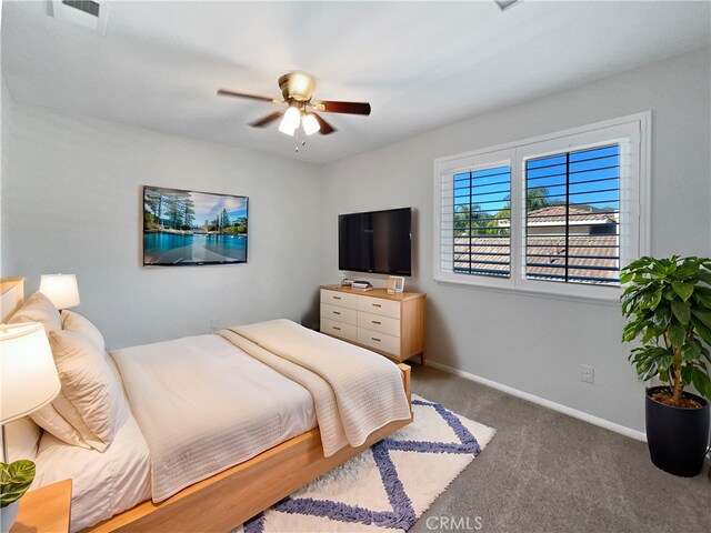 bedroom with ceiling fan and dark colored carpet