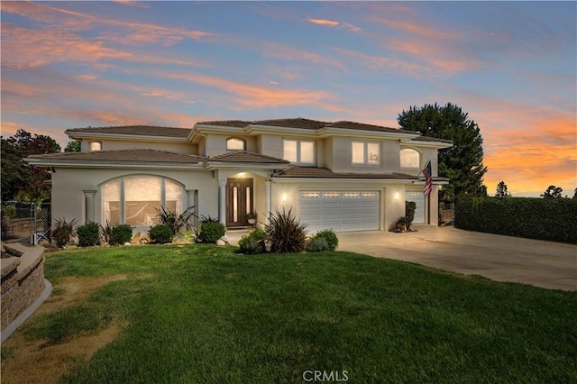 prairie-style home featuring a lawn and a garage