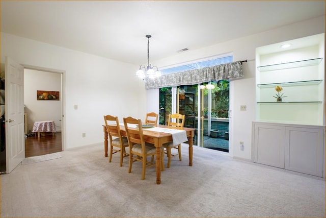 dining room with light colored carpet and a chandelier