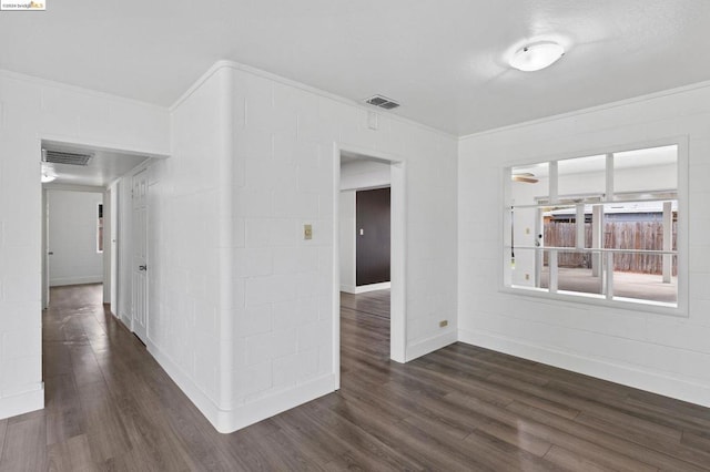 empty room featuring ornamental molding and dark wood-type flooring