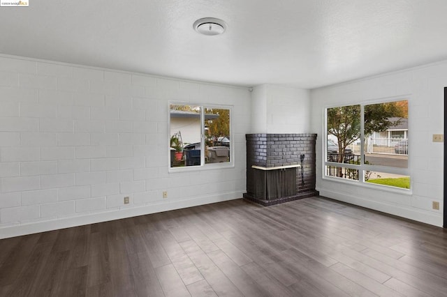 unfurnished room with dark hardwood / wood-style flooring and a brick fireplace