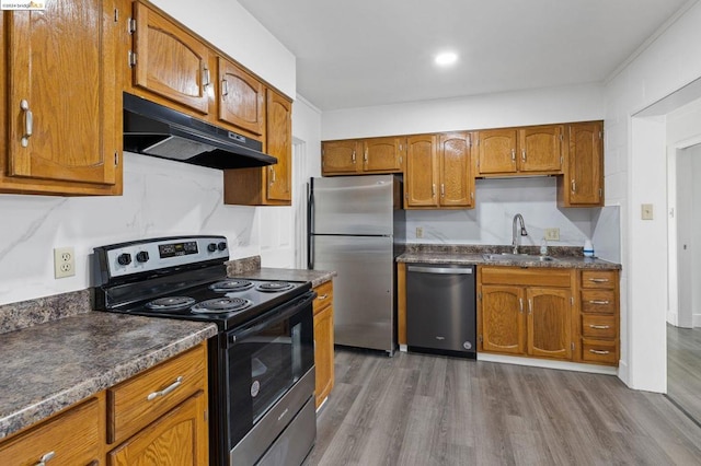 kitchen with sink, stainless steel appliances, and light hardwood / wood-style flooring