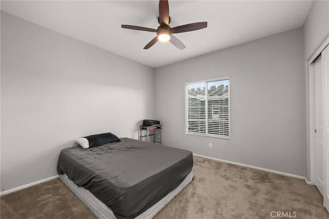 carpeted bedroom featuring a closet and ceiling fan