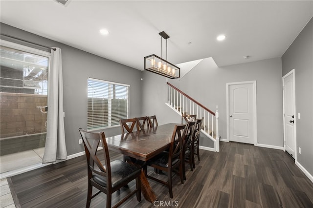 dining area with dark hardwood / wood-style floors and a chandelier