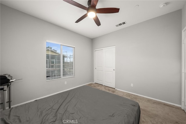 unfurnished bedroom featuring carpet flooring, ceiling fan, and a closet