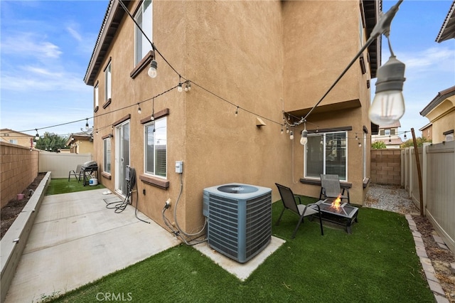 back of property featuring a fire pit, a patio area, and central AC unit