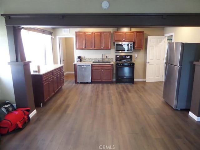 kitchen with stainless steel appliances, dark wood-type flooring, and sink