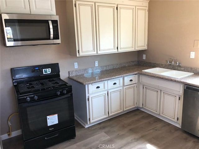 kitchen with white cabinetry, sink, light hardwood / wood-style floors, and appliances with stainless steel finishes