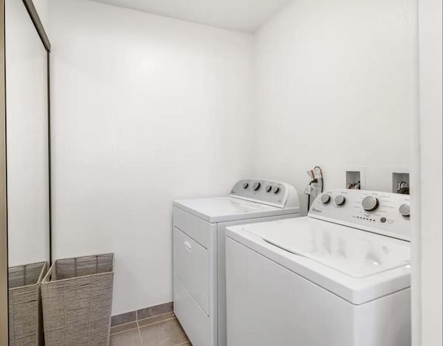 clothes washing area with light tile patterned flooring and washing machine and dryer