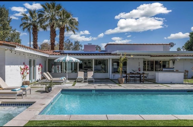 back of property with a patio area and exterior kitchen