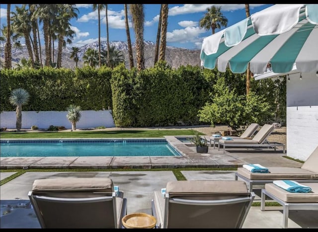 view of swimming pool with a mountain view and a patio