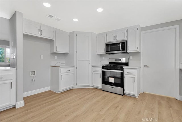 kitchen featuring white cabinetry, appliances with stainless steel finishes, and light hardwood / wood-style flooring