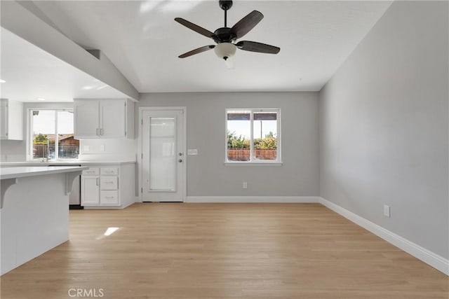 kitchen with white cabinets, light hardwood / wood-style floors, and ceiling fan