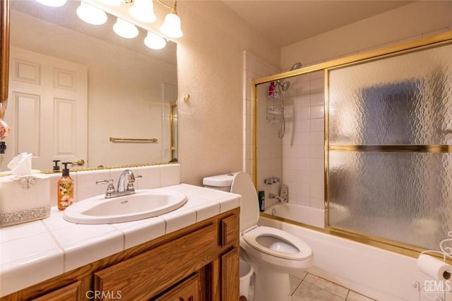 full bathroom featuring tile patterned flooring, vanity, toilet, and enclosed tub / shower combo