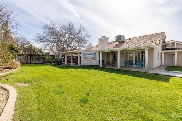 back of property with a lawn, a patio area, and central air condition unit