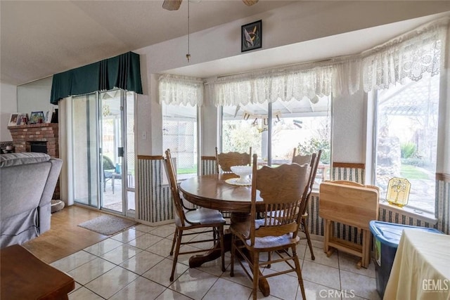 dining room with a brick fireplace, a wealth of natural light, and light wood-type flooring