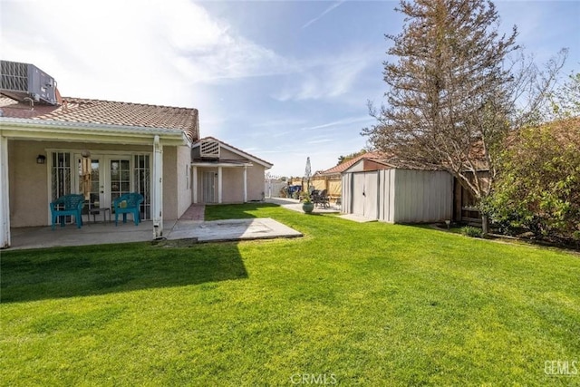 view of yard with a patio, central AC unit, and a storage unit